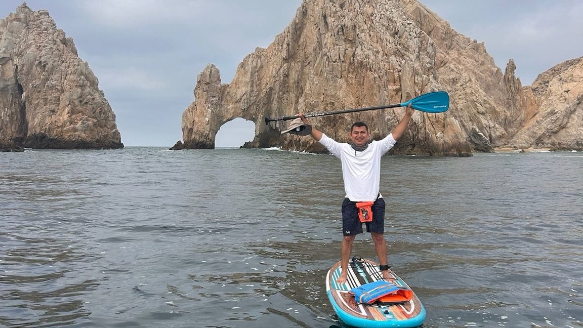 Participante celebrando con el remo en alto frente al Arco
