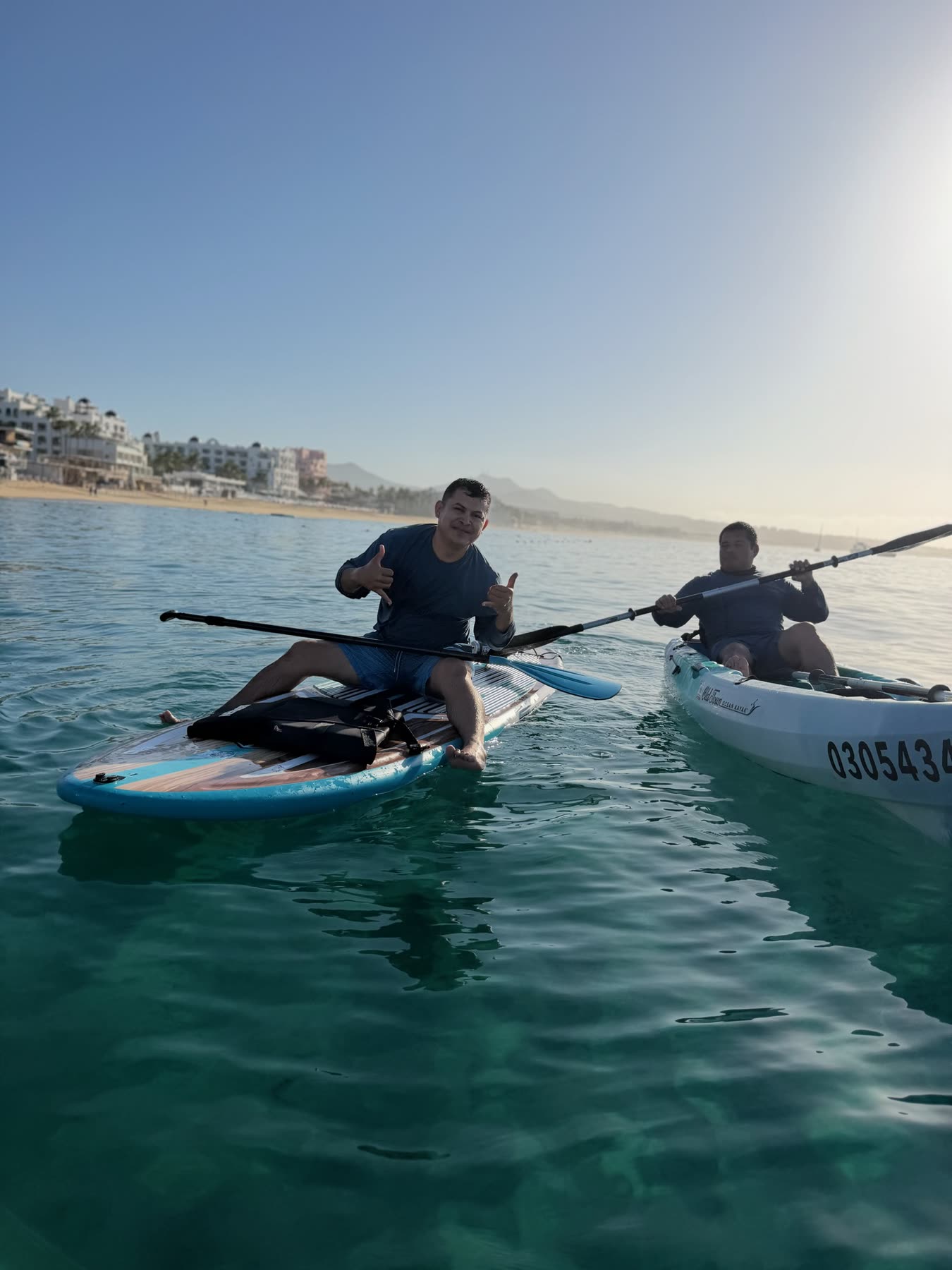 Grupo de amigos recostados en sus tablas de paddle cerca del Arco